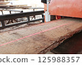 Machine for cutting boards at sawmill. Laser marking on machine. Wooden board. Wood processing at sawmill. 125988357