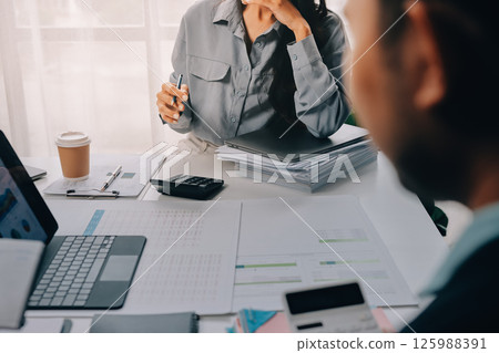 Team of financial advisory services. Asian advisor showing plan of investment to clients in the consultancy office. 125988391