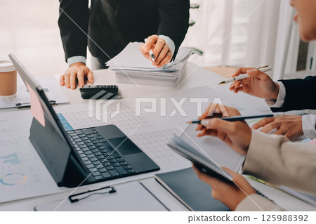 Team of financial advisory services. Asian advisor showing plan of investment to clients in the consultancy office. 125988392