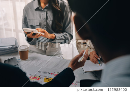 Team of financial advisory services. Asian advisor showing plan of investment to clients in the consultancy office. 125988400