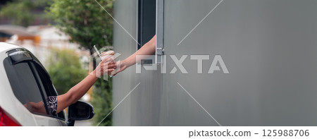 Hand Man in car receiving coffee in drive thru fast food restaurant. Hand Man in car receiving coffee in drive thru fast food restaurant. 125988706