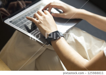 Woman hand with smart watch on wrist, wearable watch and technology computer laptop for communication, checking time. Woman hand with smart watch on wrist, wearable watch and technology computer laptop for communication, checking time. 125988811