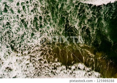 Aerial view Top down Waves crashing on sandy shore,Dark sea surface in summer day background,Seascape top view waves at Phuket Thailand 125989288