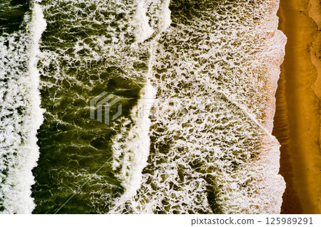Aerial view Top down Waves crashing on sandy shore,Dark sea surface in summer day background,Seascape top view waves at Phuket Thailand 125989291