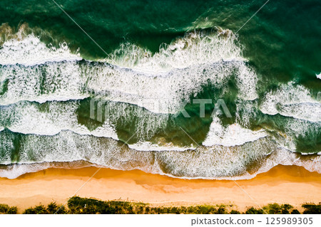 Aerial view Top down Waves crashing on sandy shore,Dark sea surface in summer day background,Seascape top view waves at Phuket Thailand Aerial view Top down Waves crashing on sandy shore,Dark sea surface in summer day background,Seascape top view waves at Phuket Thailand 125989305
