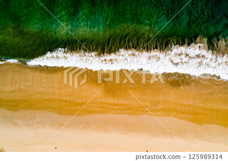Aerial view Top down Waves crashing on sandy shore,Dark sea surface in summer day background,Seascape top view waves at Phuket Thailand 125989314