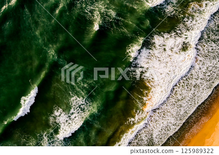Aerial view Top down Waves crashing on sandy shore,Dark sea surface in summer day background,Seascape top view waves at Phuket Thailand 125989322