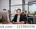 Businesswoman sitting and analyzing business performance in office 125989396