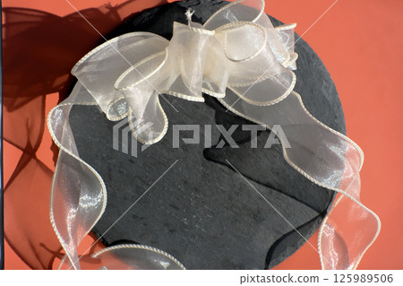 Lace ribbon photographed against a red background 125989506