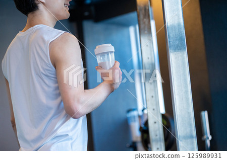Japanese man having protein shake at gym Japanese man having protein shake at gym 125989931