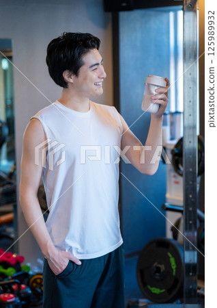 Japanese man having protein shake at gym 125989932