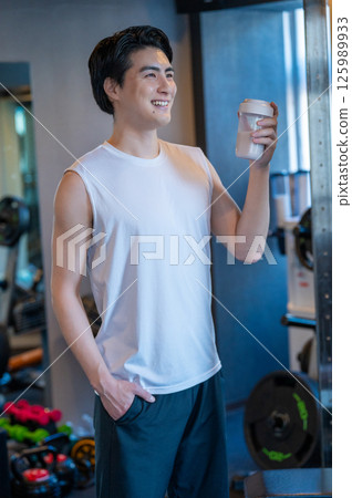 Japanese man having protein shake at gym Japanese man having protein shake at gym 125989933