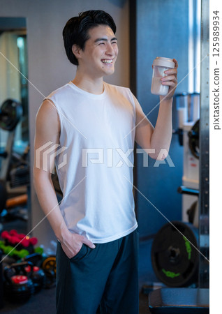 Japanese man having protein shake at gym Japanese man having protein shake at gym 125989934