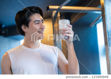 Japanese man having protein shake at gym 125989949