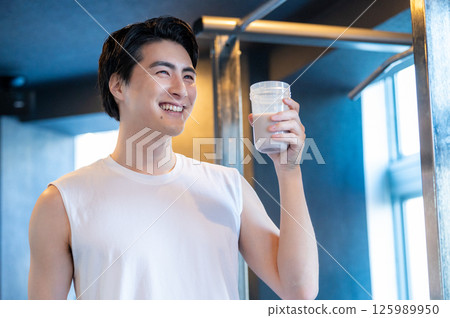 Japanese man having protein shake at gym 125989950