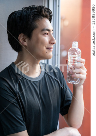 Japanese man drinking water at the gym Japanese man drinking water at the gym 125989980