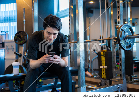 一名日本男子在健身房操作智慧型手機 125989995