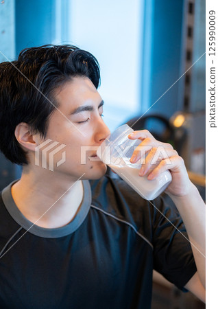 Japanese man drinking protein at the gym Japanese man drinking protein at the gym 125990009
