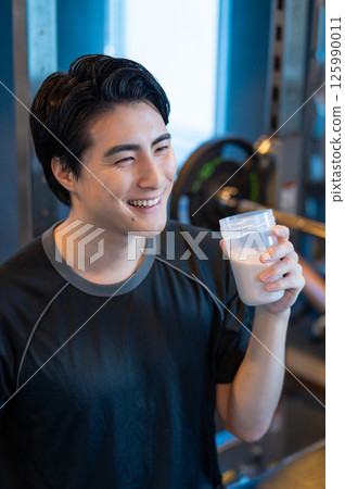 Japanese man drinking protein at the gym 125990011