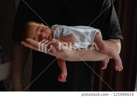 Newborn Baby Cradled in Hand 125990028