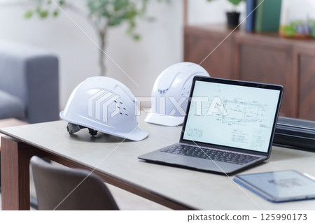 辦公室裡的頭盔和筆記型電腦（無人值守） 125990173