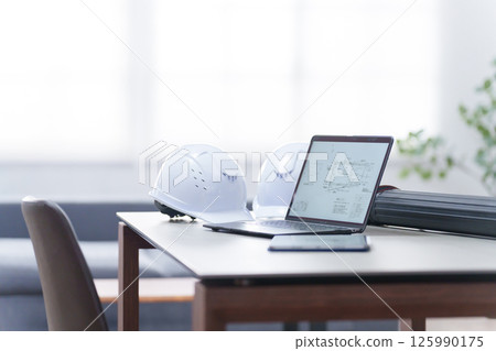 Helmet and laptop in the office (unmanned) 125990175