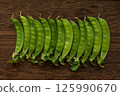 Snow peas lined up in a row 125990670