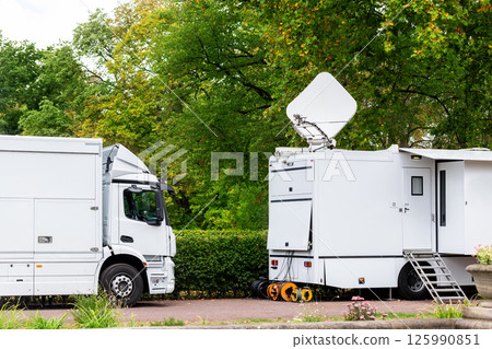 Many modern white mobile digital electric tv broadcasting trucks satellite antenna live streaming online breaking news sport channel city park. Internet communication media vehice network equipment Many modern white mobile digital electric tv broadcasting trucks satellite antenna live streaming online breaking news sport channel city park. Internet communication media vehice network equipment 125990851