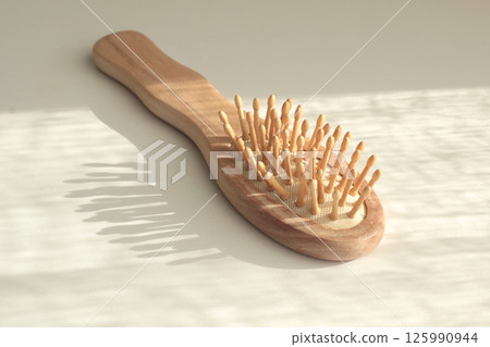 Wooden massage comb. Body and hair care. Natural material and ecology. Protection of nature. Wooden massage comb. Body and hair care. Natural material and ecology. Protection of nature. 125990944