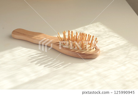 Wooden massage comb. Body and hair care. Natural material and ecology. Protection of nature. Wooden massage comb. Body and hair care. Natural material and ecology. Protection of nature. 125990945