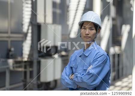 一名 30 多歲的男子身穿工作服，看著鏡頭。圖片為一名建築維護人員 125990992