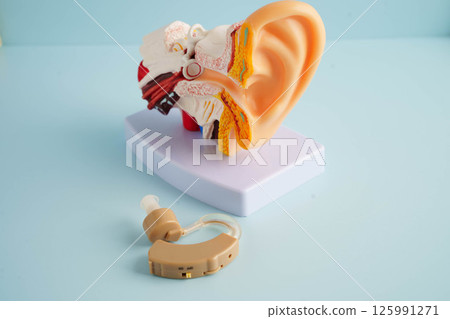 Otoscope with ear model for otolaryngologist or ENT physician doctor examining senior patient ear, hearing loss problem. 125991271