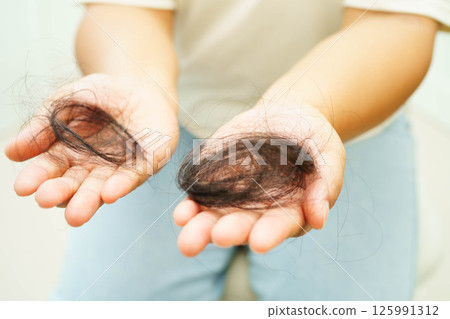 Asian woman have problem with long hair loss attach in her hand. 125991312