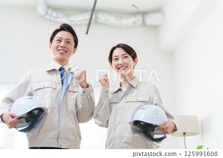 A contractor in work clothes holding a helmet A contractor in work clothes holding a helmet 125991608