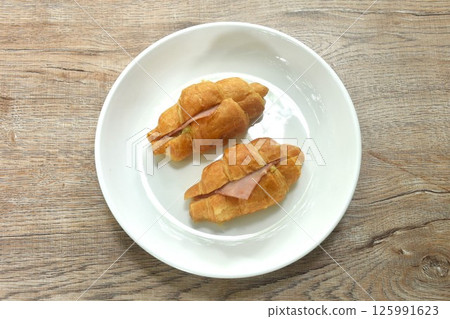 baking crispy butter croissant French bread stuffed ham cheese and spinach on plate baking crispy butter croissant French bread stuffed ham cheese and spinach on plate 125991623