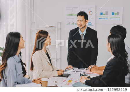 Team of financial advisory services. Asian advisor showing plan of investment to clients in the consultancy office. 125992319