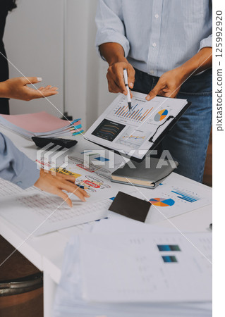 Team of financial advisory services. Asian advisor showing plan of investment to clients in the consultancy office. 125992920