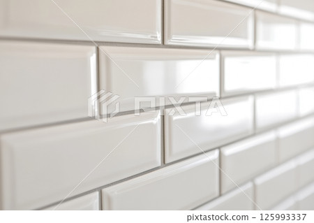 Ceramic tiles with a glossy finish and beveled edges set into horizontal brickwork. The sleek and clean wall design is ideal for kitchens and bathrooms with a minimalist or modern aesthetic. Banner Ceramic tiles with a glossy finish and beveled edges set into horizontal brickwork. The sleek and clean wall design is ideal for kitchens and bathrooms with a minimalist or modern aesthetic. Banner 125993337