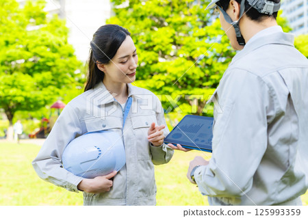 Male and female workers consulting while looking at a tablet 125993359