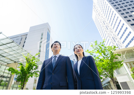 一群商人站在綠樹成蔭的城市中的仰視鏡頭 一群商人站在綠樹成蔭的城市中的仰視鏡頭 125993398
