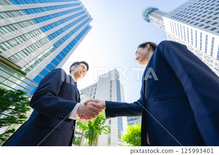 一群商務人士在綠樹成蔭的城市中握手的鳥瞰圖 一群商務人士在綠樹成蔭的城市中握手的鳥瞰圖 125993401