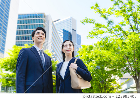 Low angle composition of a group of business people standing in a city with fresh greenery 125993405