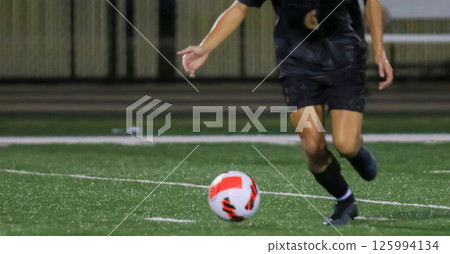 Soccer Player About to Kick Ball on Field During Night Match Under the Lights 125994134