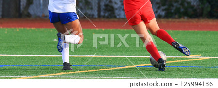 Soccer player dribbling the ball down the field with the defender chasing during a game 125994136