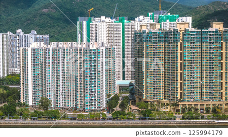 Elevated View of Urban Apartment Buildings Surrounded by Lush Green Hills May 4 2025 125994179