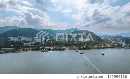 Scenic Coastal Landscape Featuring Mountains, Buildings, and Boats 125994186