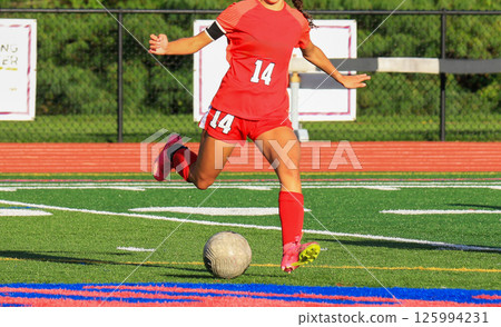 Female Soccer Player Kicking the Ball During a Game 125994231