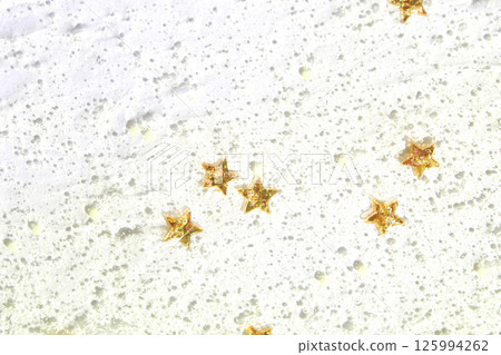 Glittery gold stars on shimmering white textured surface art background 125994262