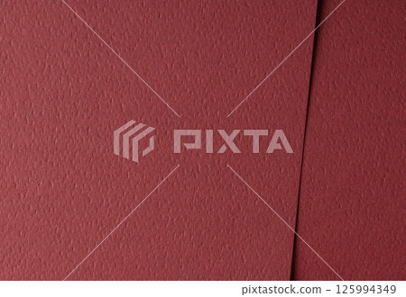 Paper texture with wine red tone, smooth matte surface and perforated geometric line overlay, maroon 125994349