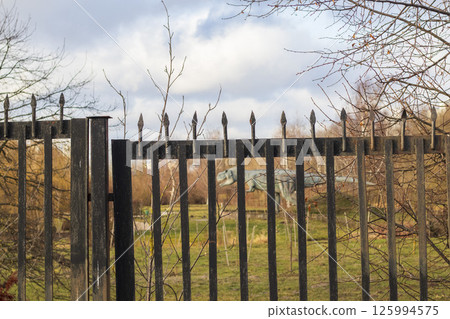 Shot of the dinosaur sculpture behind the fence Shot of the dinosaur sculpture behind the fence 125994575